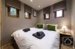 This cozy bedroom features a comfortable bed with fresh linens and plush pillows, perfect for a relaxing stay.