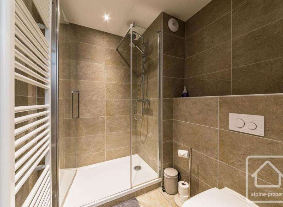 Step into this modern bathroom featuring a sleek glass shower enclosure and stylish tile work.