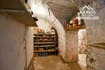 Discover the charm of this unique property! This space features a rustic, stone-walled interior with built-in shelving, perfect for storage or display.