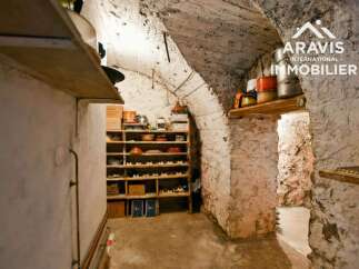 Discover the charm of this unique property! This space features a rustic, stone-walled interior with built-in shelving, perfect for storage or display.