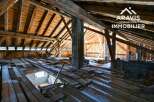 Explore the potential of this unique property! This image showcases a spacious attic with exposed wooden beams, offering a blank canvas for renovation.