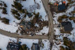 This aerial view showcases a modern home under construction in a serene, snow-covered neighborhood.