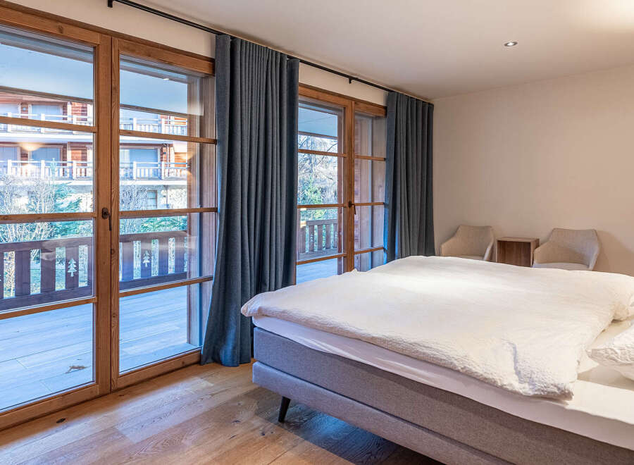 Experience the charm of this inviting bedroom, featuring stunning wooden-framed windows that flood the space with natural light.