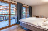 Experience the charm of this inviting bedroom, featuring stunning wooden-framed windows that flood the space with natural light.
