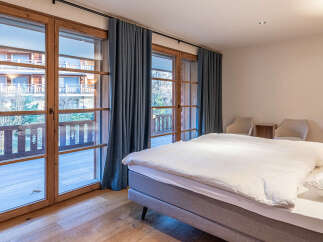 Experience the charm of this inviting bedroom, featuring stunning wooden-framed windows that flood the space with natural light.