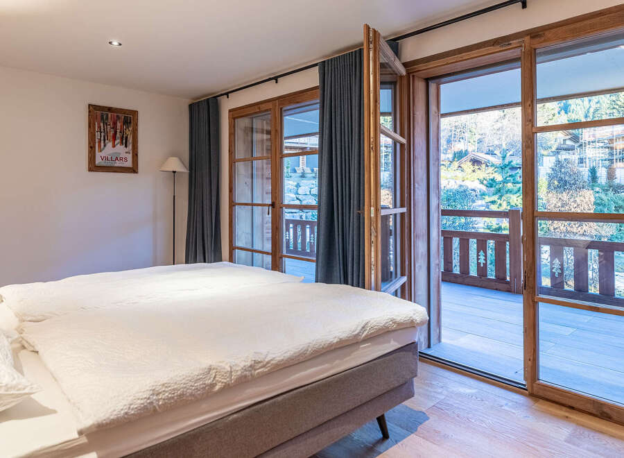 Experience the charm of this inviting bedroom, featuring a cozy bed and a stunning view.