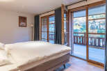Experience the charm of this inviting bedroom, featuring a cozy bed and a stunning view.