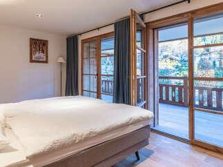 Experience the charm of this inviting bedroom, featuring a cozy bed and a stunning view.