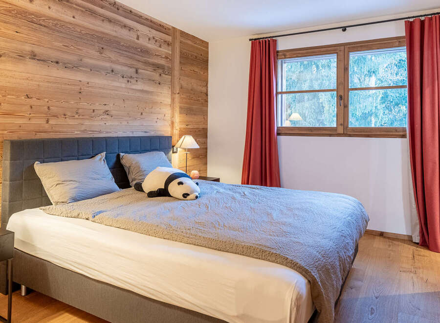 This cozy bedroom features a stunning wooden accent wall, creating a warm and inviting atmosphere.