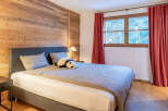 This cozy bedroom features a stunning wooden accent wall, creating a warm and inviting atmosphere.