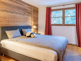 This cozy bedroom features a stunning wooden accent wall, creating a warm and inviting atmosphere.