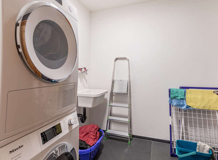 This laundry room offers a functional and organized space for all your washing needs.