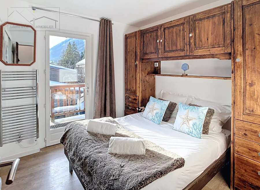 This cozy bedroom features a comfortable bed with plush pillows and a warm, inviting blanket.