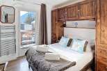 This cozy bedroom features a comfortable bed with plush pillows and a warm, inviting blanket.