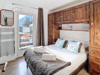 This cozy bedroom features a comfortable bed with plush pillows and a warm, inviting blanket.