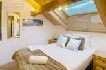 Discover the charm of this cozy bedroom, featuring a comfortable bed with plush bedding and decorative pillows.