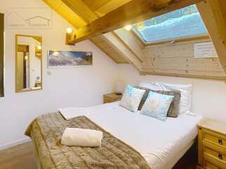 Discover the charm of this cozy bedroom, featuring a comfortable bed with plush bedding and decorative pillows.