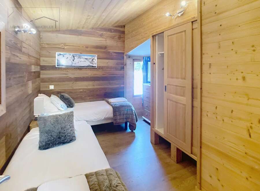 This cozy bedroom features beautiful wooden walls and ceilings, creating a warm and inviting atmosphere.