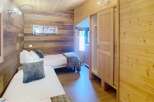 This cozy bedroom features beautiful wooden walls and ceilings, creating a warm and inviting atmosphere.
