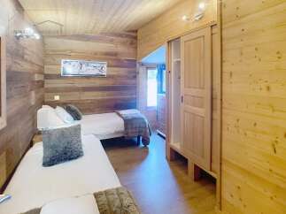 This cozy bedroom features beautiful wooden walls and ceilings, creating a warm and inviting atmosphere.
