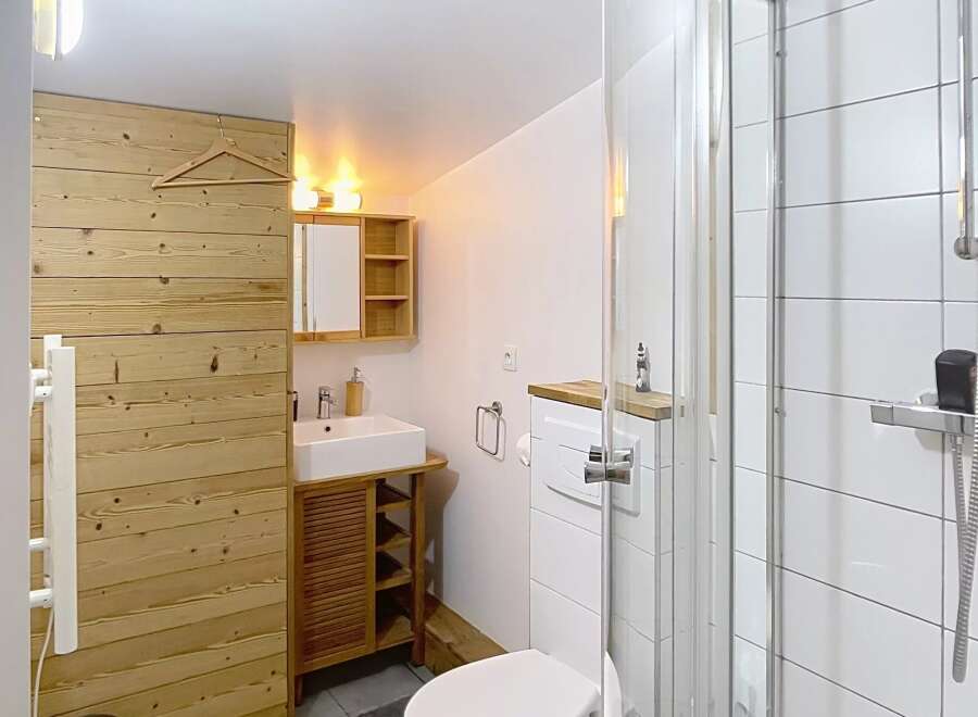 Discover this charming bathroom featuring a modern shower, a sleek toilet, and a stylish vanity.