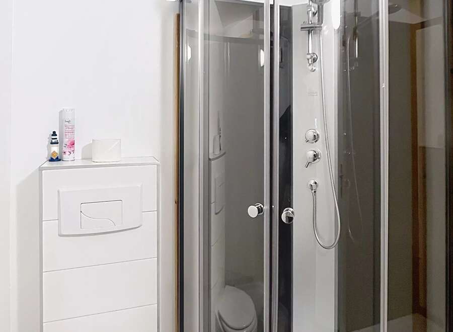 This modern bathroom features a sleek, corner shower with glass doors, offering a spa-like experience.