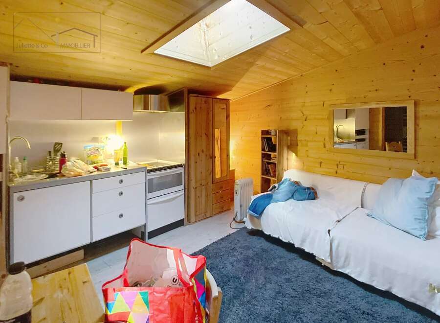 Discover this charming property featuring a cozy interior with wooden paneling and a skylight that fills the space with natural light.