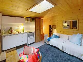 Discover this charming property featuring a cozy interior with wooden paneling and a skylight that fills the space with natural light.