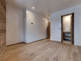 This stunning property boasts a modern interior with beautiful wooden floors and walls, creating a warm and inviting atmosphere.