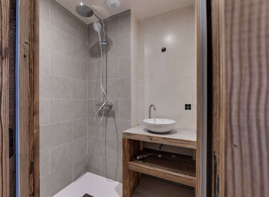Step into a modern bathroom oasis! This stunning space features a sleek shower with a rainfall showerhead and a stylish sink area.