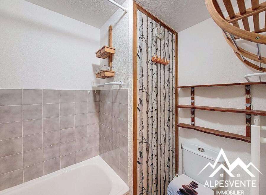 Discover this charming bathroom featuring a unique birch tree-themed accent wall, adding a touch of nature-inspired elegance.