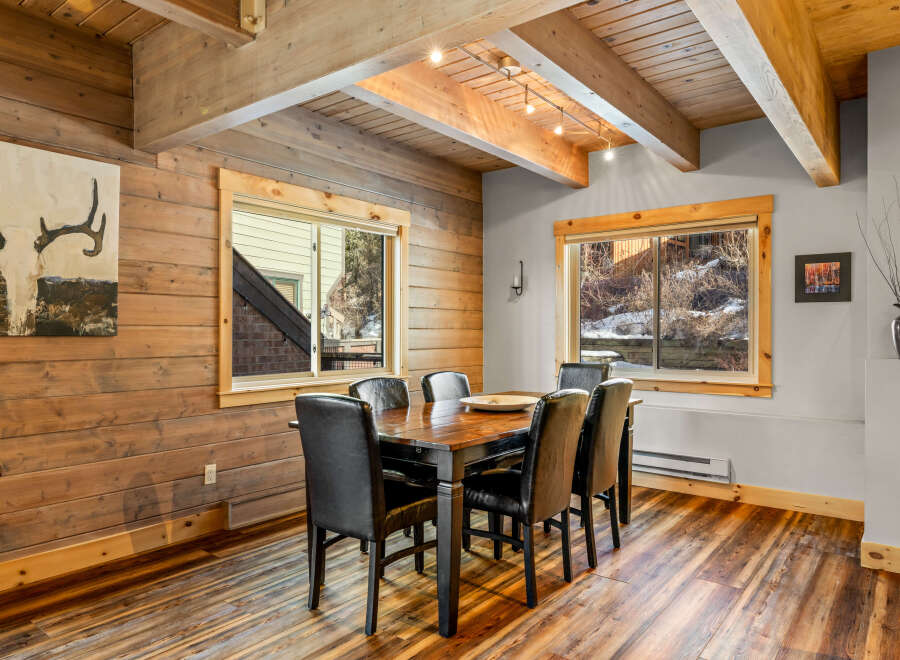 This stunning dining room features a rustic design with wood paneling and a beautiful wooden table.