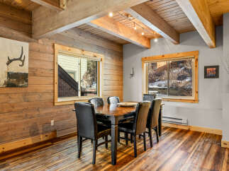 This stunning dining room features a rustic design with wood paneling and a beautiful wooden table.