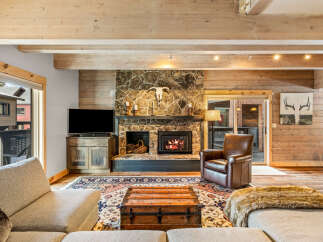 Step into luxury with this stunning living space, featuring a cozy fireplace and a rustic, inviting ambiance.
