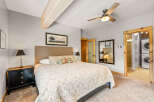 This inviting bedroom boasts a cozy ambiance with its plush bedding and neutral color palette.