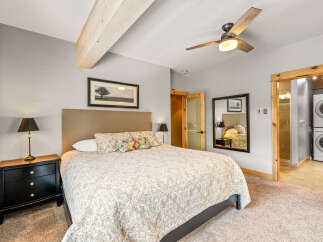 This inviting bedroom boasts a cozy ambiance with its plush bedding and neutral color palette.