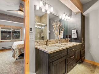 This stunning bathroom boasts a modern design with a double vanity and granite countertops, offering ample space and luxury.