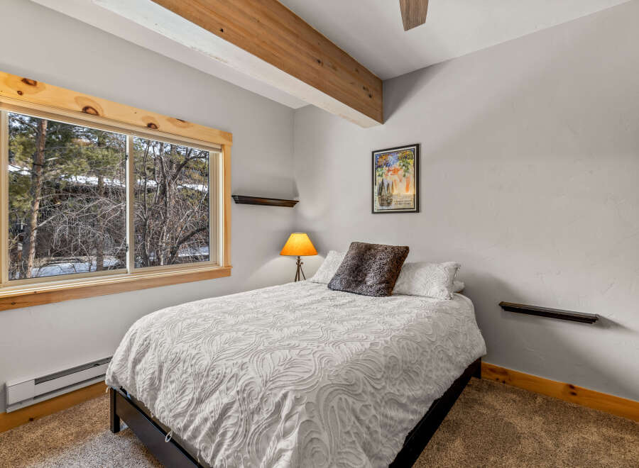 This cozy bedroom features a comfortable bed with a decorative comforter and pillows.
