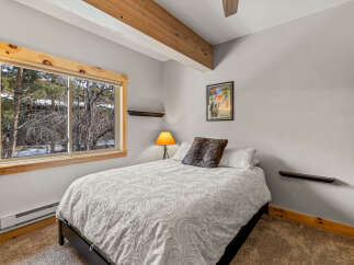 This cozy bedroom features a comfortable bed with a decorative comforter and pillows.
