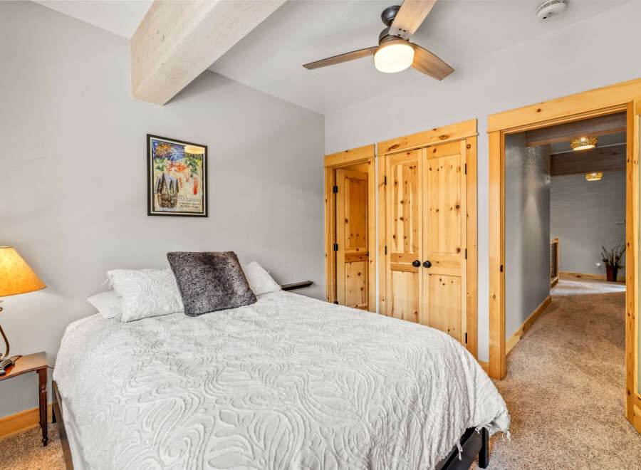This cozy bedroom features a comfortable bed with a stylish white comforter and a decorative pillow.