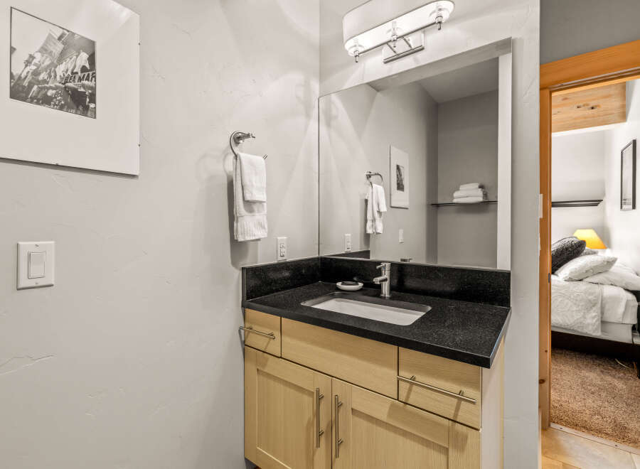 This stunning bathroom boasts a sleek black countertop and a modern sink, perfect for a stylish and functional space.