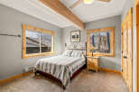 This cozy bedroom features a comfortable bed with a striped comforter, perfect for a relaxing retreat.