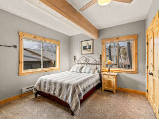 This cozy bedroom features a comfortable bed with a striped comforter, perfect for a relaxing retreat.