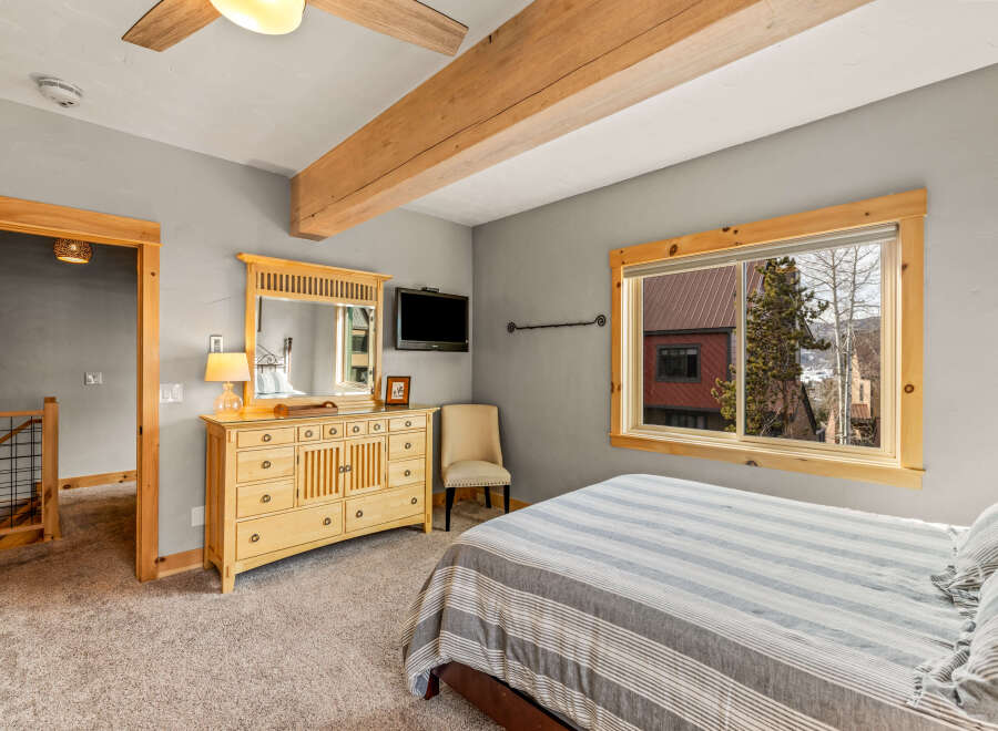 This cozy bedroom features a comfortable bed with striped bedding, perfect for a relaxing retreat.