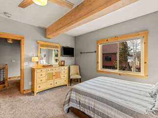 This cozy bedroom features a comfortable bed with striped bedding, perfect for a relaxing retreat.