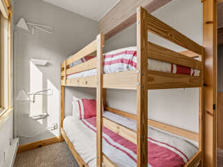This cozy bedroom features a charming bunk bed, perfect for accommodating guests or family members.