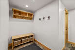 This entryway features a custom-built wooden bench with woven baskets, perfect for storing shoes and accessories.
