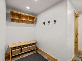 This entryway features a custom-built wooden bench with woven baskets, perfect for storing shoes and accessories.