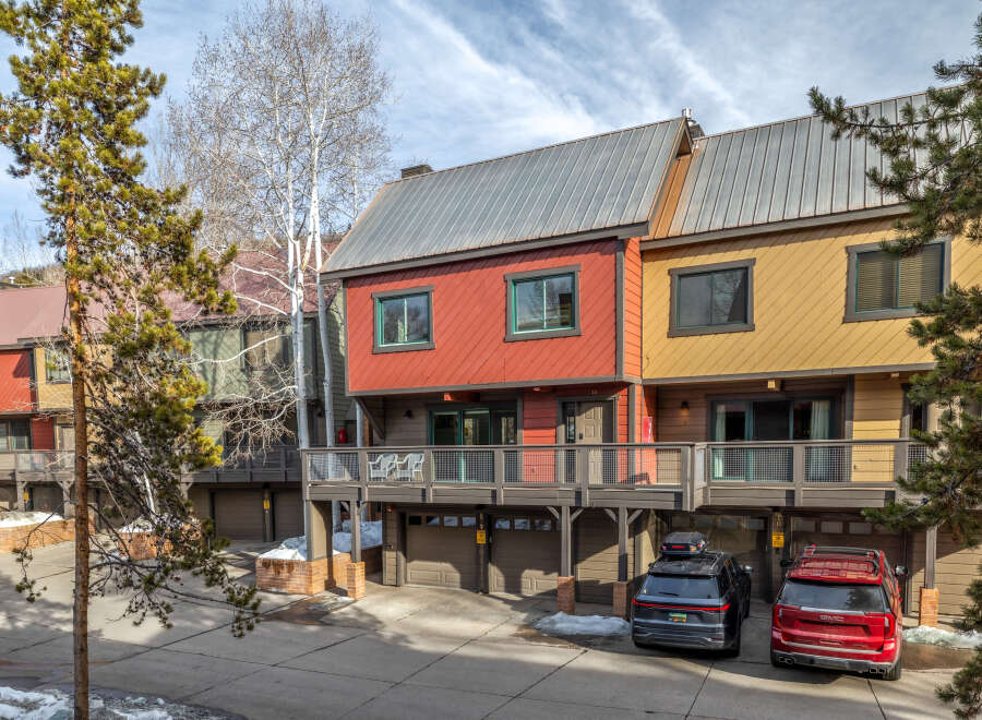 Discover the charm of this stunning property featuring a vibrant red and yellow exterior, complemented by a modern metal roof.