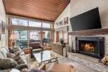 Experience luxury living in this stunning property, featuring a cozy fireplace and a sleek, modern TV.